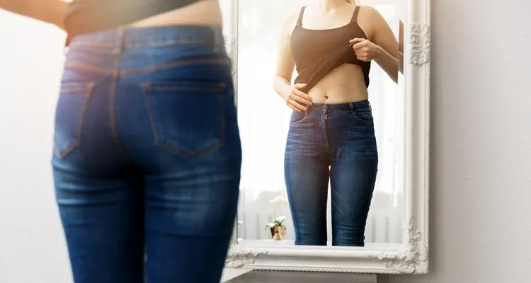 A woman checking her body shape in the mirror