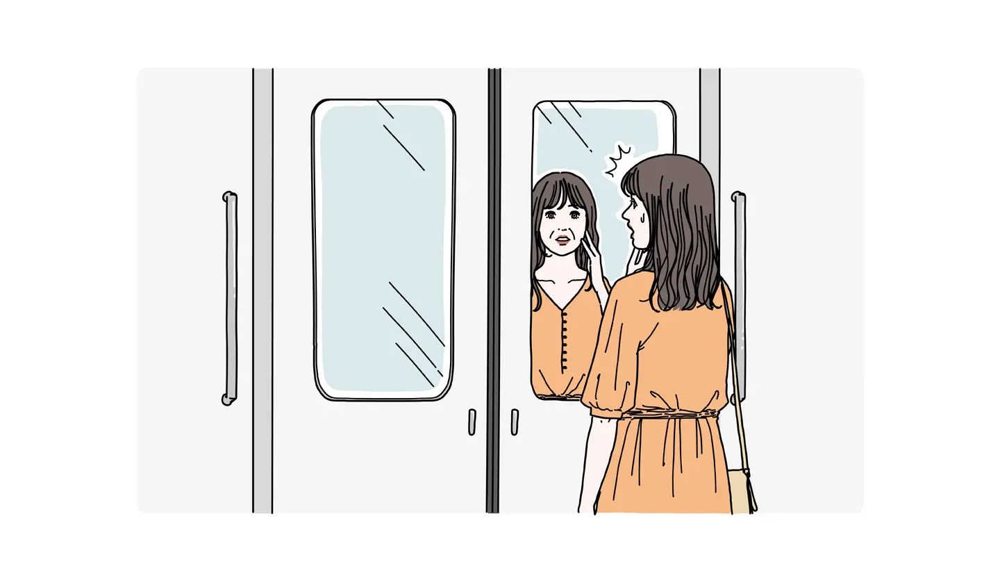 電車の窓に映った自分の顔にほうれい線を見つけてショックを受ける女性