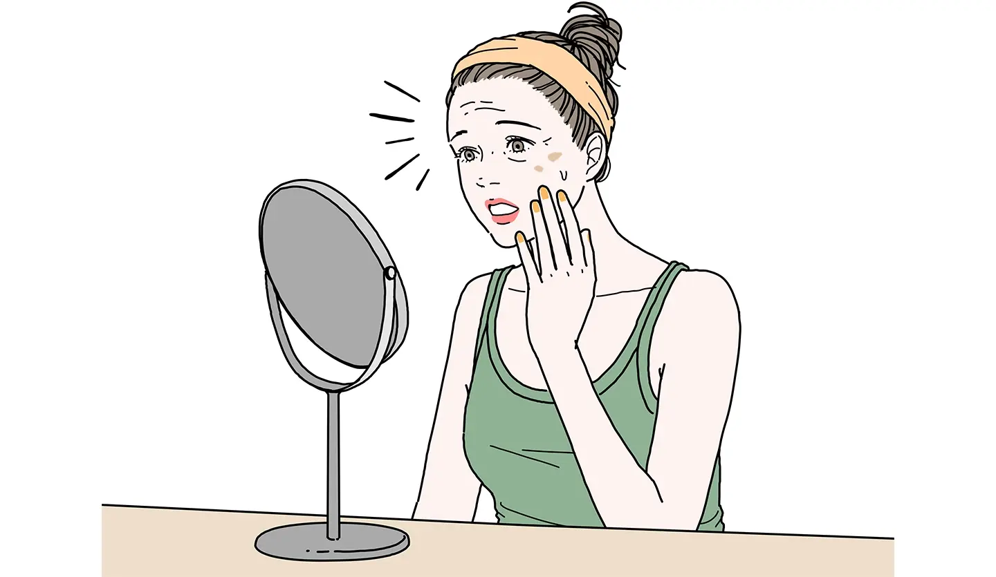 鏡で肌を確認する女性